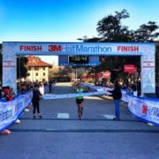 Runner crosses 3M Half Marathon finish line