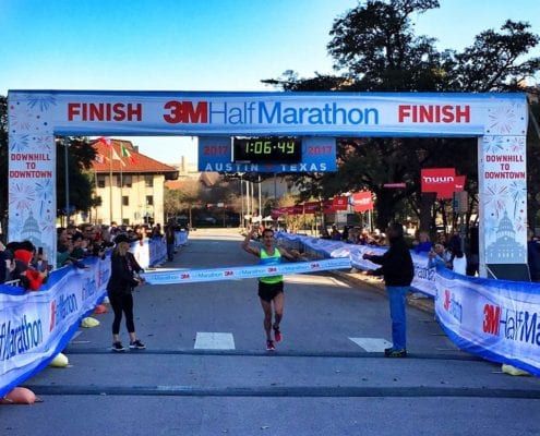 Runner crosses 3M Half Marathon finish line