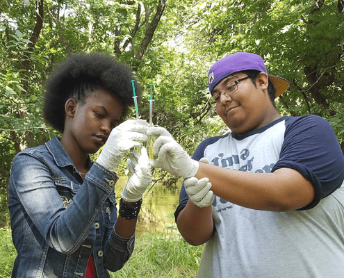 Youth River Watch members examining water quality samples