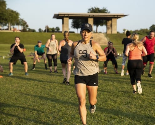 Determined woman finishing rep of a cross training exercise in Camp Gladiator