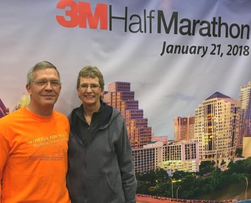 Happy couple standing in front of 3M Half Marathon poster