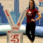 Brittany Bussey, 2020 3M Half Ambassador, poses with giant 2019 3M Half Marathon medal.