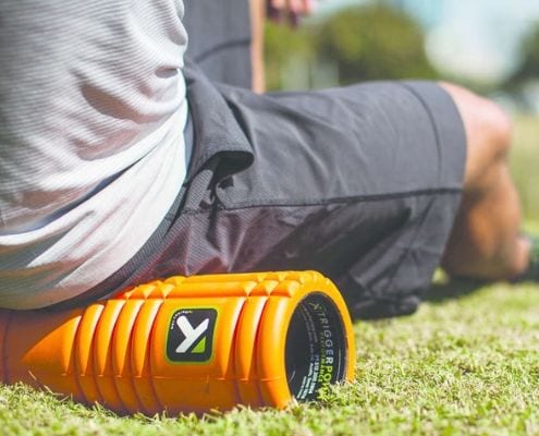 Runner is foam rolling to help muscles recover.