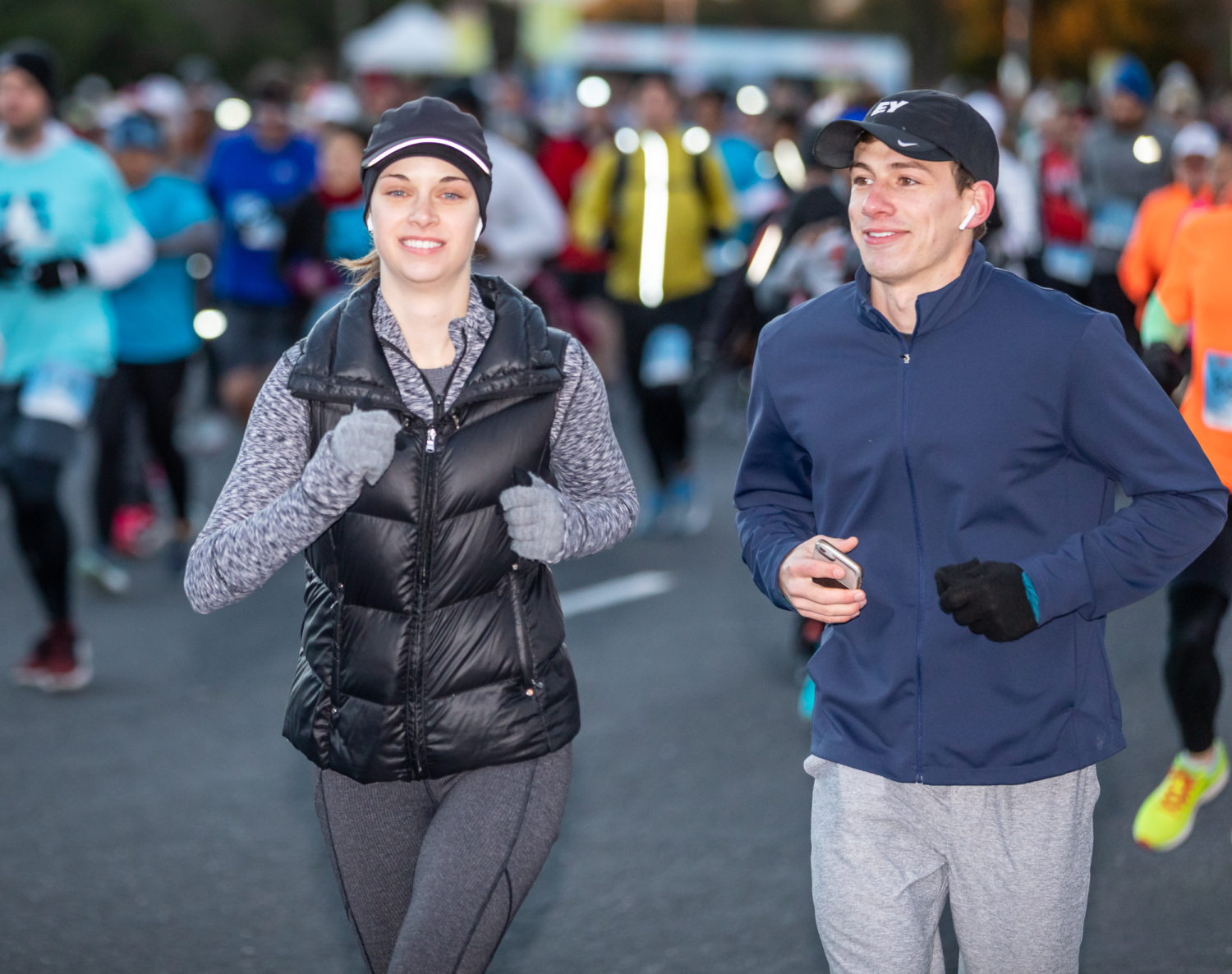 Two runners stay safe by running together and carrying their phone.