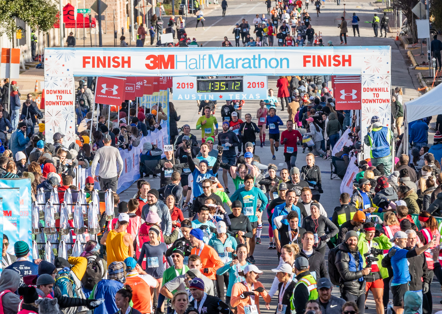 Runners cross the 2019 3M Half Marathon presented by Under Armour finish line.