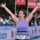 Runner crosses the 2019 3M Half Marathon finish line wearing her SPIbelt. SPIbelt is the Official Race Belt of the 2020 3M Half Marathon presented by Under Armour.
