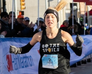 Image of Jess Harper as she crosses the 2019 3M Half Marathon finish line as the female champ. She is the 2018 and 2019 female champ and will run with the 2020 elite field.