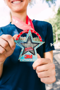 Image of runner showcasing the 2020 3M Half Marathon finisher medal. This blog has everything you need to get ready for the 2020 3M Half Marathon!