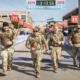 Image of four soldiers crossing the 2019 3M Half Marathon finish line in full gear. Meet our friends will make 2020 3M Half Marathon unforgettable and remember running is better with friends.