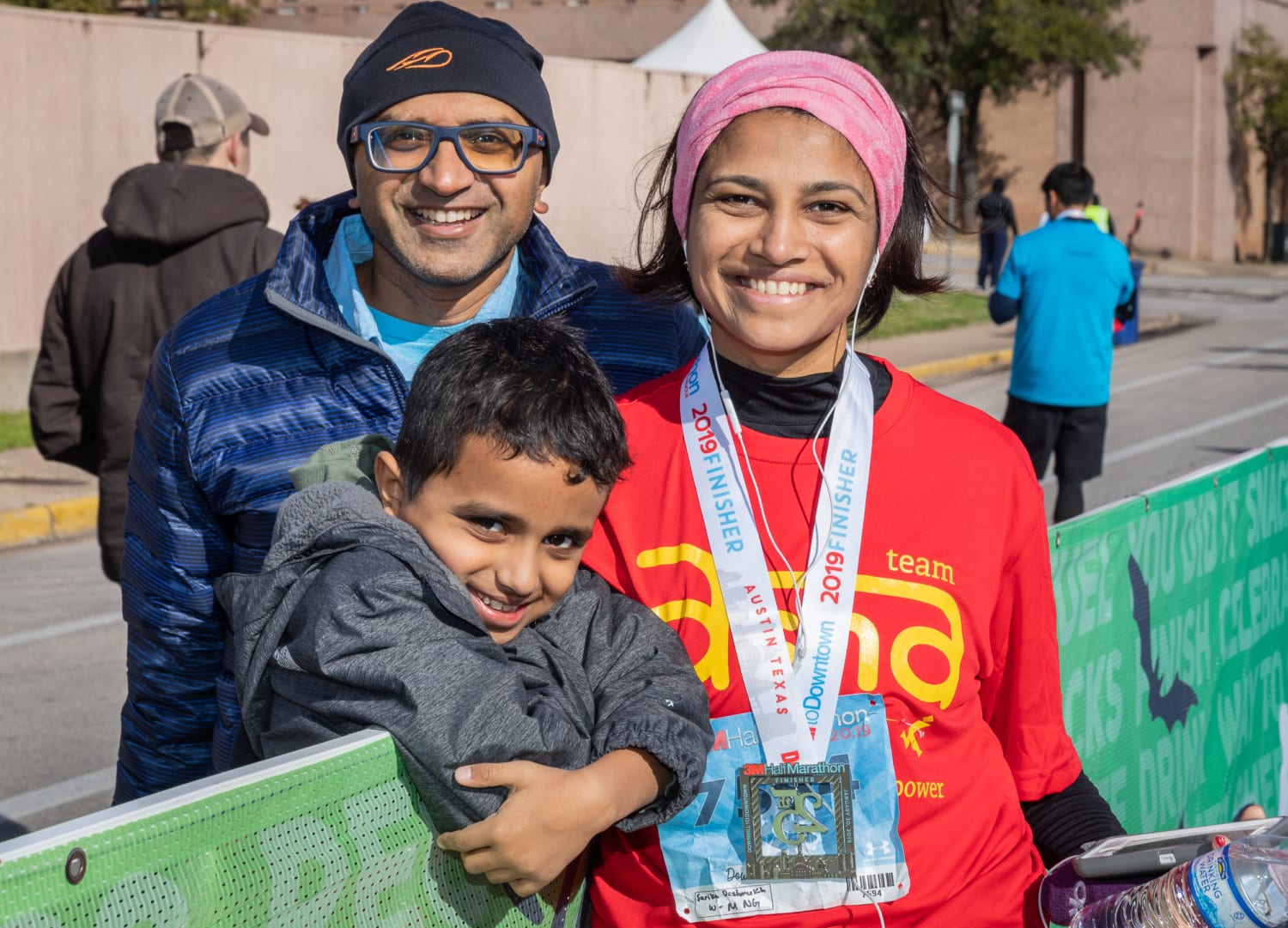 Image of a mom posing with her son and husband at the 2019 3M Half Marathon finish line. Nominate your mom in this blog post for the Mother's Day giveaway!