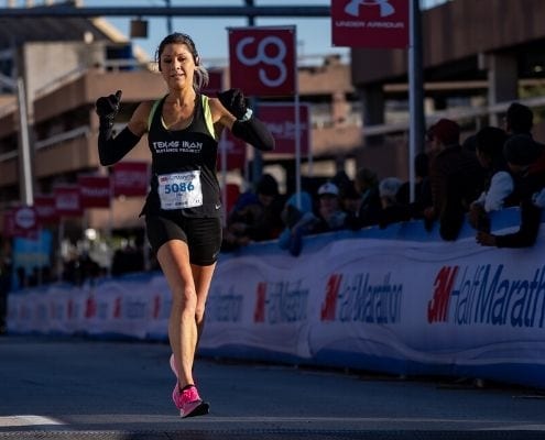 A female runner cruises to the 2020 3M Half Marathon finish line. The tips and advice in this blog will help you grow as a runner and prepare for your next finish line.