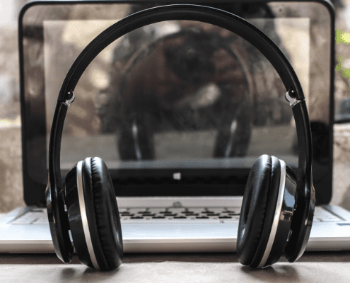 Image of headphones sitting in front of a laptop. Read this blog to learn what the staff at High Five Events would listen to forever.