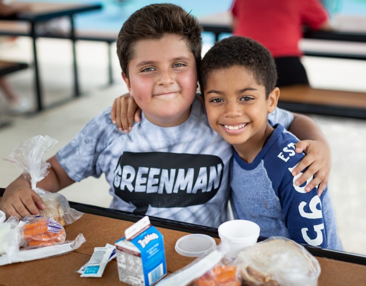 Two children enjoy a meal from the Central Texas Food Bank, the 2021 beneficiary of the 3M Half Marathon.