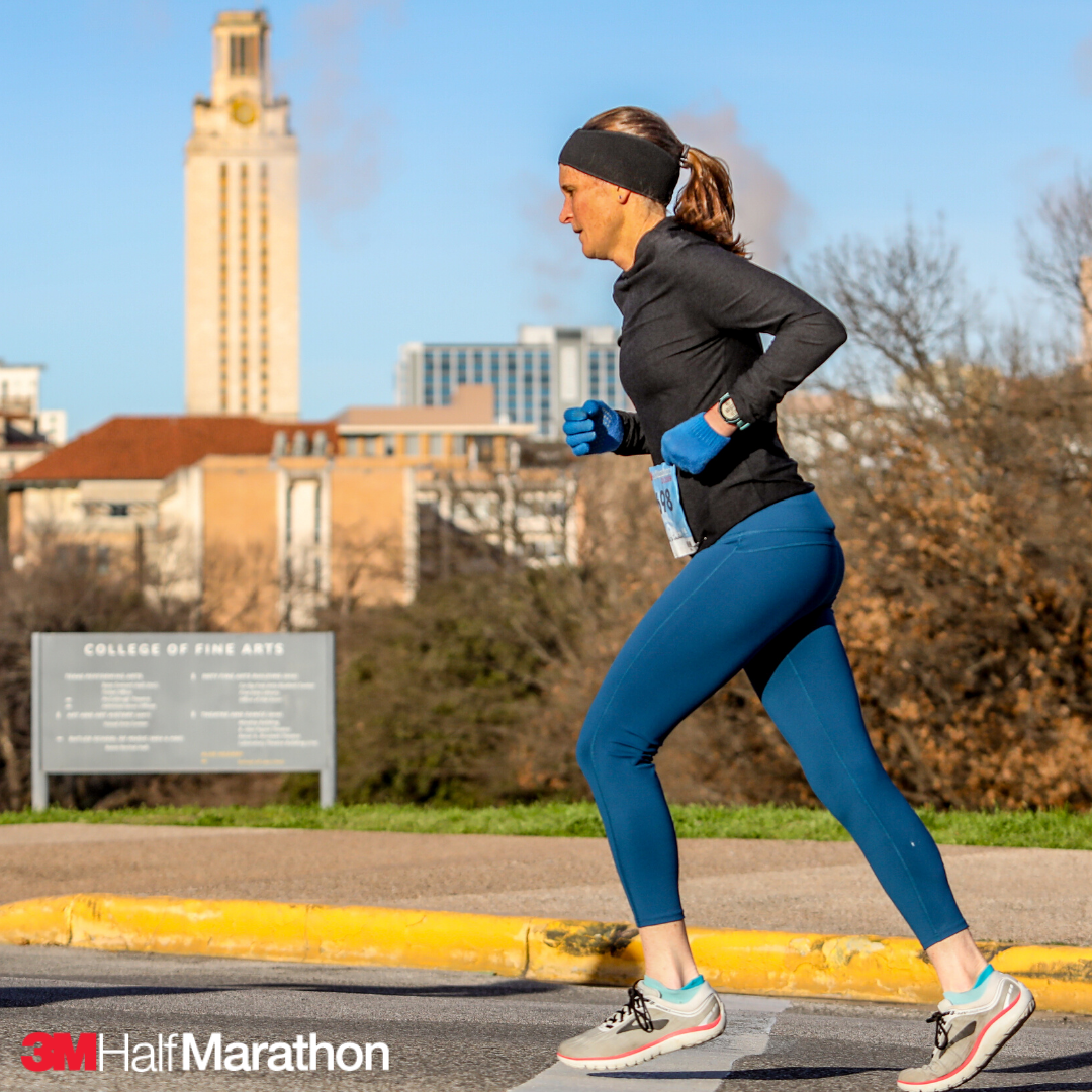 Female runner during the 2019 3M Half Marathon. She's running towards the finish line in running shoes specifically for running. Use our tips to ensure you pick the right running shoes for you at https://downhilltodowntown.com/right-running-shoes-for-you/