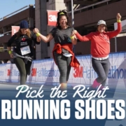 Three female runners excitedly cross the 2020 3M Half Marathon finish line while holding their hands in the air. Selecting the right running shoes for you will help you reach the finish line. Read more at https://downhilltodowntown.com/right-running-shoes-for-you/
